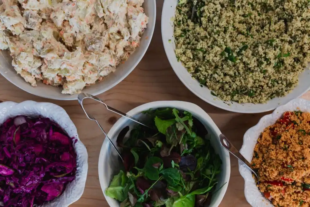 A table at Yvette's Pantry in Carbis Bay, showcasing an array of colourful bowls filled with delicious food options, a great place for food and drink in Carbis Bay.