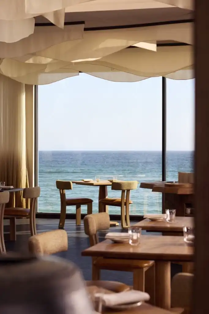 Interior of MOR restaurant in Carbis Bay, featuring tables and chairs with a stunning ocean view, a great place for food and drink in Carbis Bay.