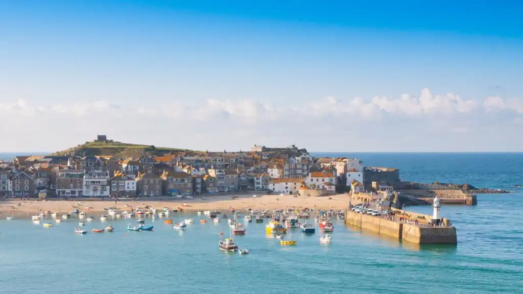 Scenic view of St Ives Harbour in Cornwall, showcasing boats and vibrant buildings along the waterfront, close by to lots of options for parking in St Ives.